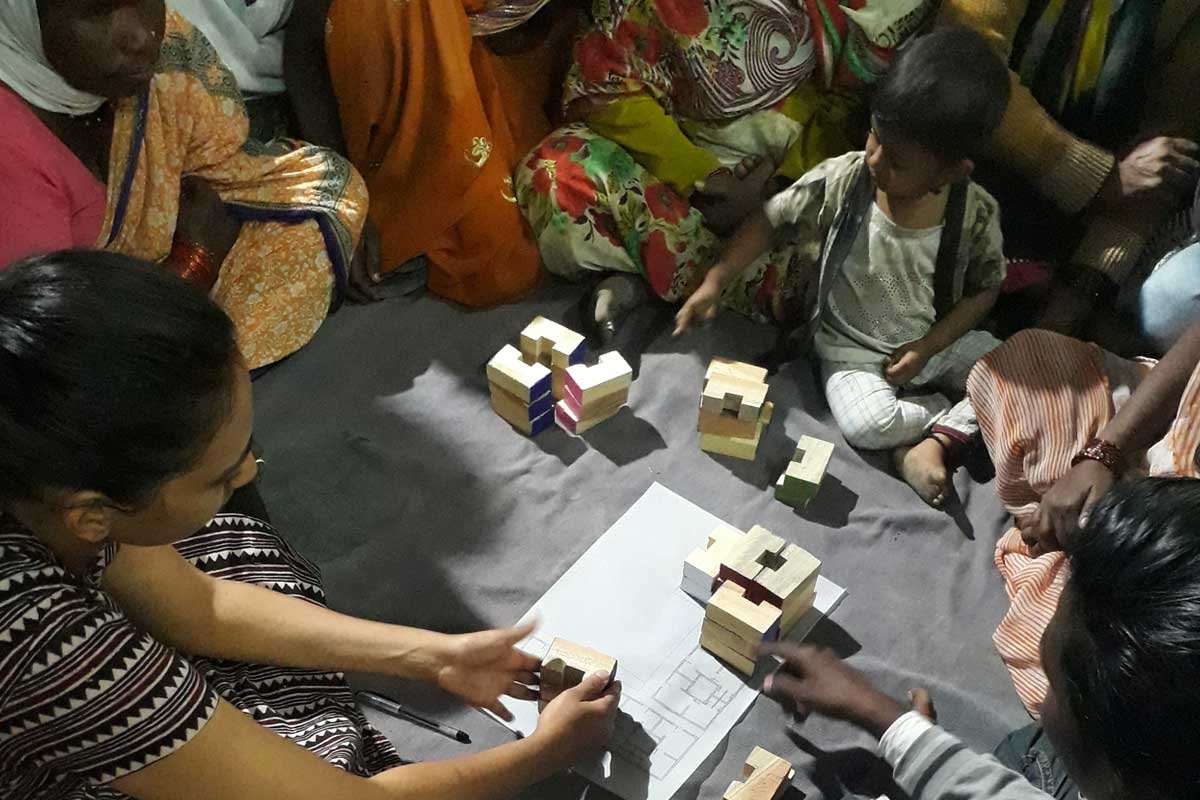 People sitting on the floor around playing blocks